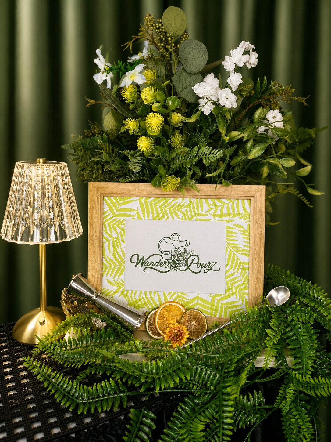 Wander Pourz floral setup with glowing gold lamp and framed logo